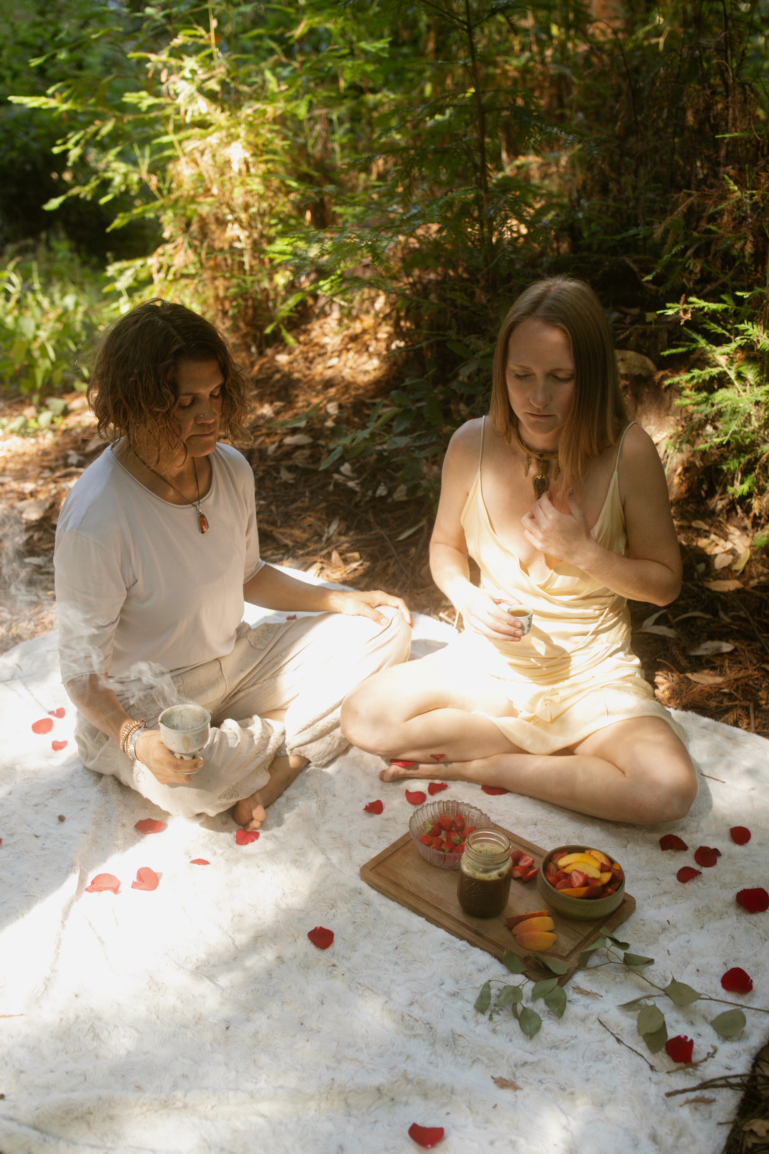 Two participants in white clothing in ceremonial integration session at Tree of Life Temple 7-Day Fall Equinox Retreat Mendocino County