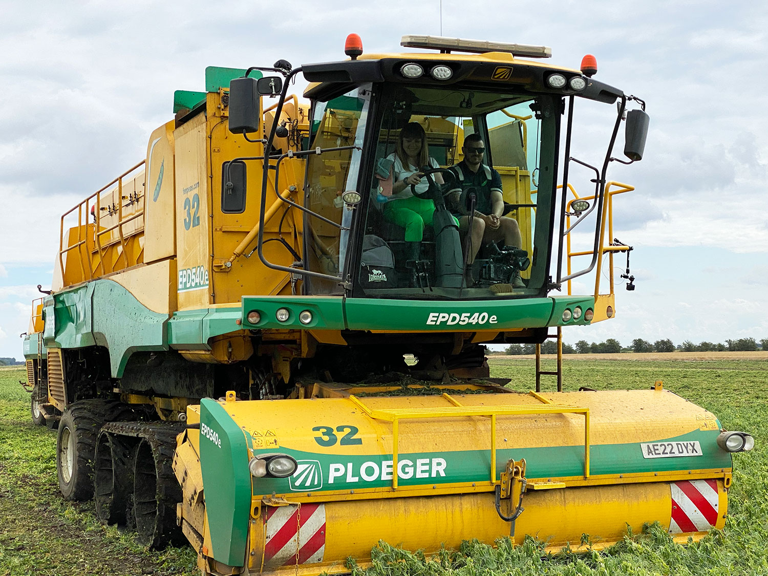Briony Williams in the cab of a Ploeger pea harvester. Briony is driving and has a member of the farm team sat with her in the cab.