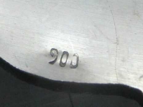 Close-up of a 900 hallmark on silver hollowware representing coin silver purity standards.