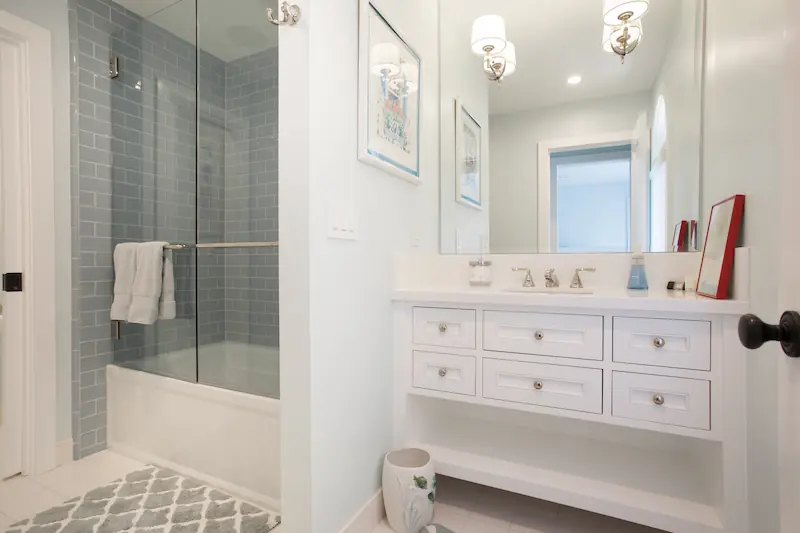 Cozy secondary bathroom with custom vanity, patterned tile flooring and walk-in shower from the Big Canyon Remodel project. Photo by Chris Darnall.