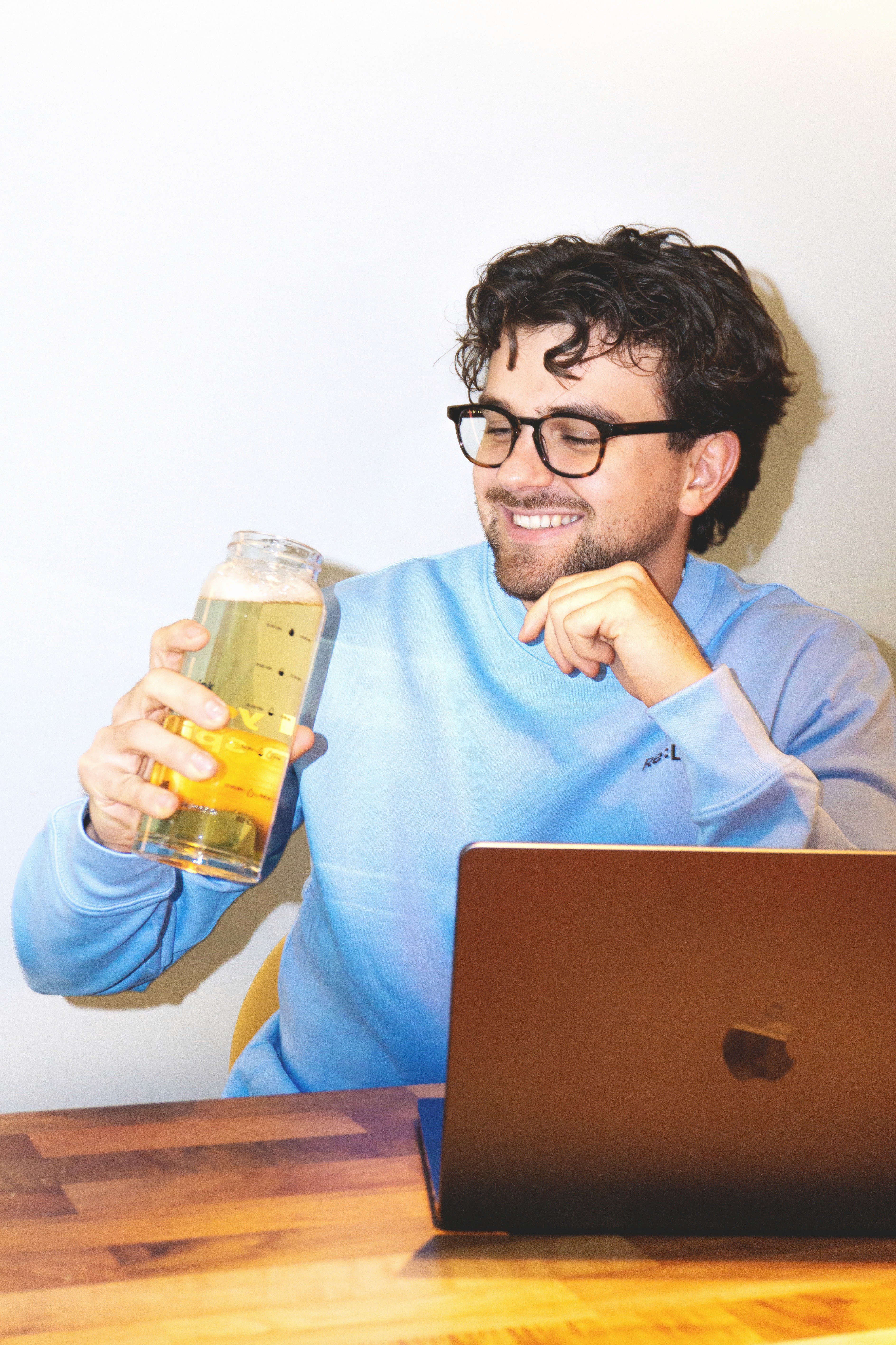 Ein glücklicher Mensch am Schreibtisch mit einem leckeren Getränk in der Hand