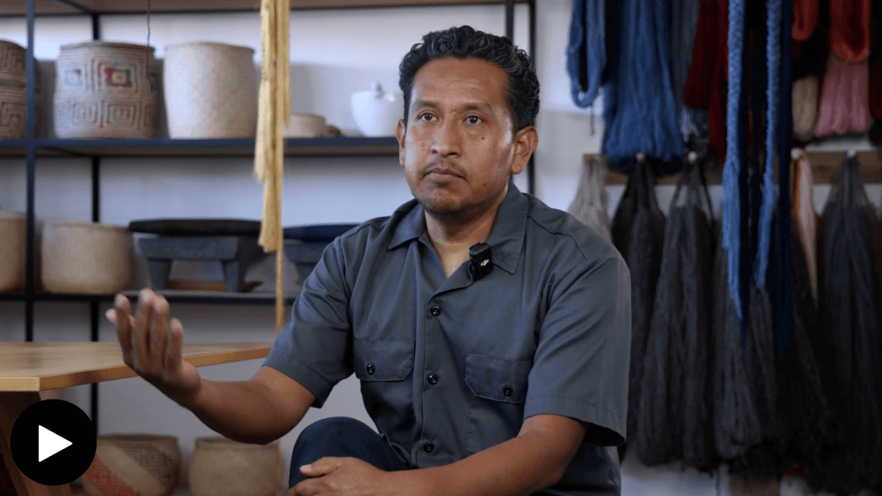 Porfirio Giutierrez in his studio, with ceramics and yarn behind him.