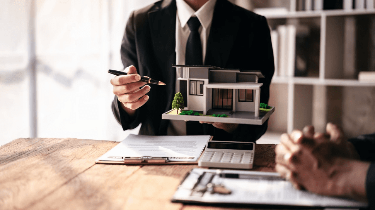 Bussiness Man showing liability protection on a house.