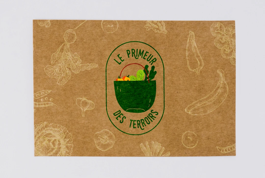 Mockup carte en papier kraft avec le logo badge Le Primeur des Terroirs et son pattern de légumes illustrés — identité visuelle pour primeur bio sur les marchés d'Occitanie, Tartelette Concept