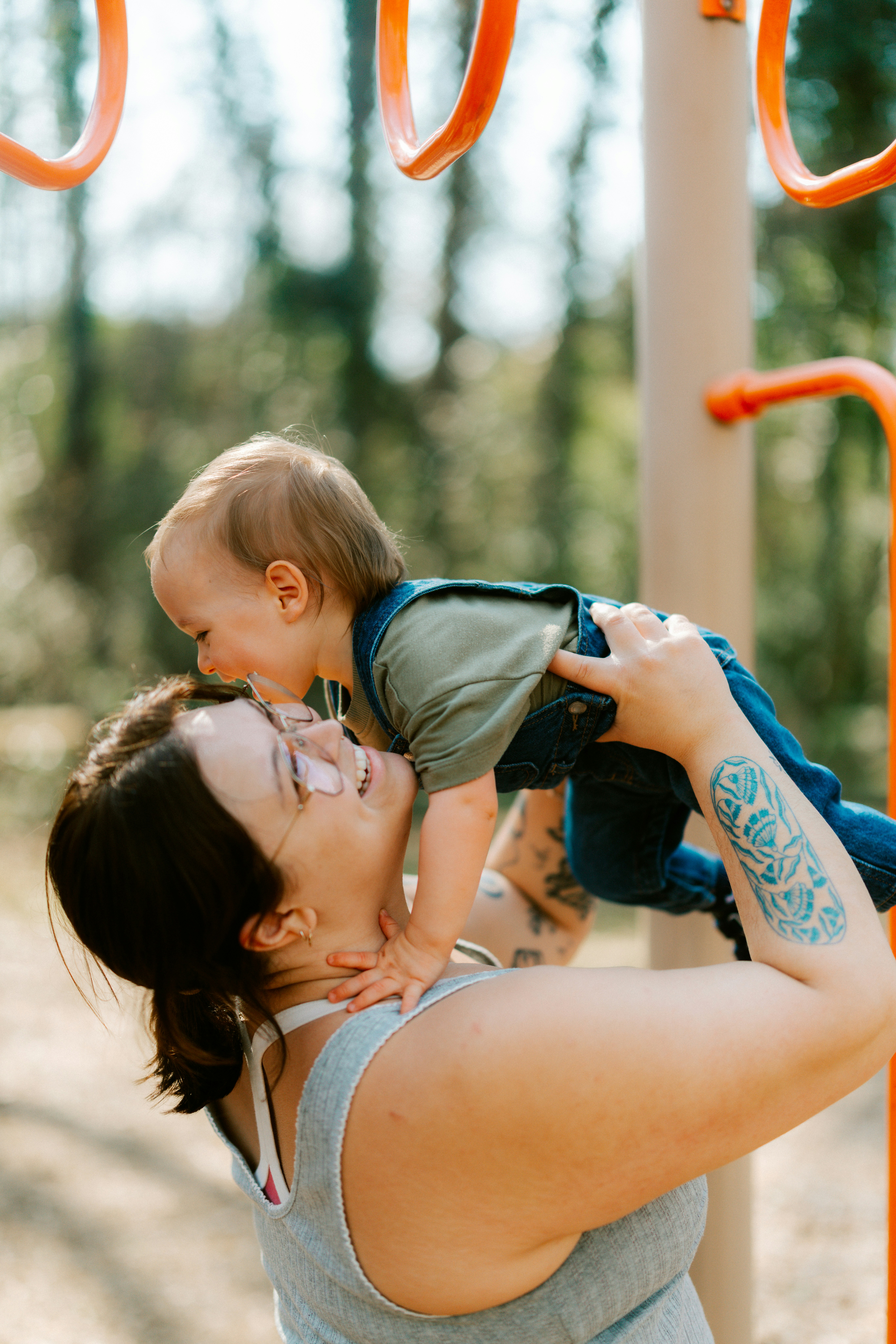Mother holds baby up at playground