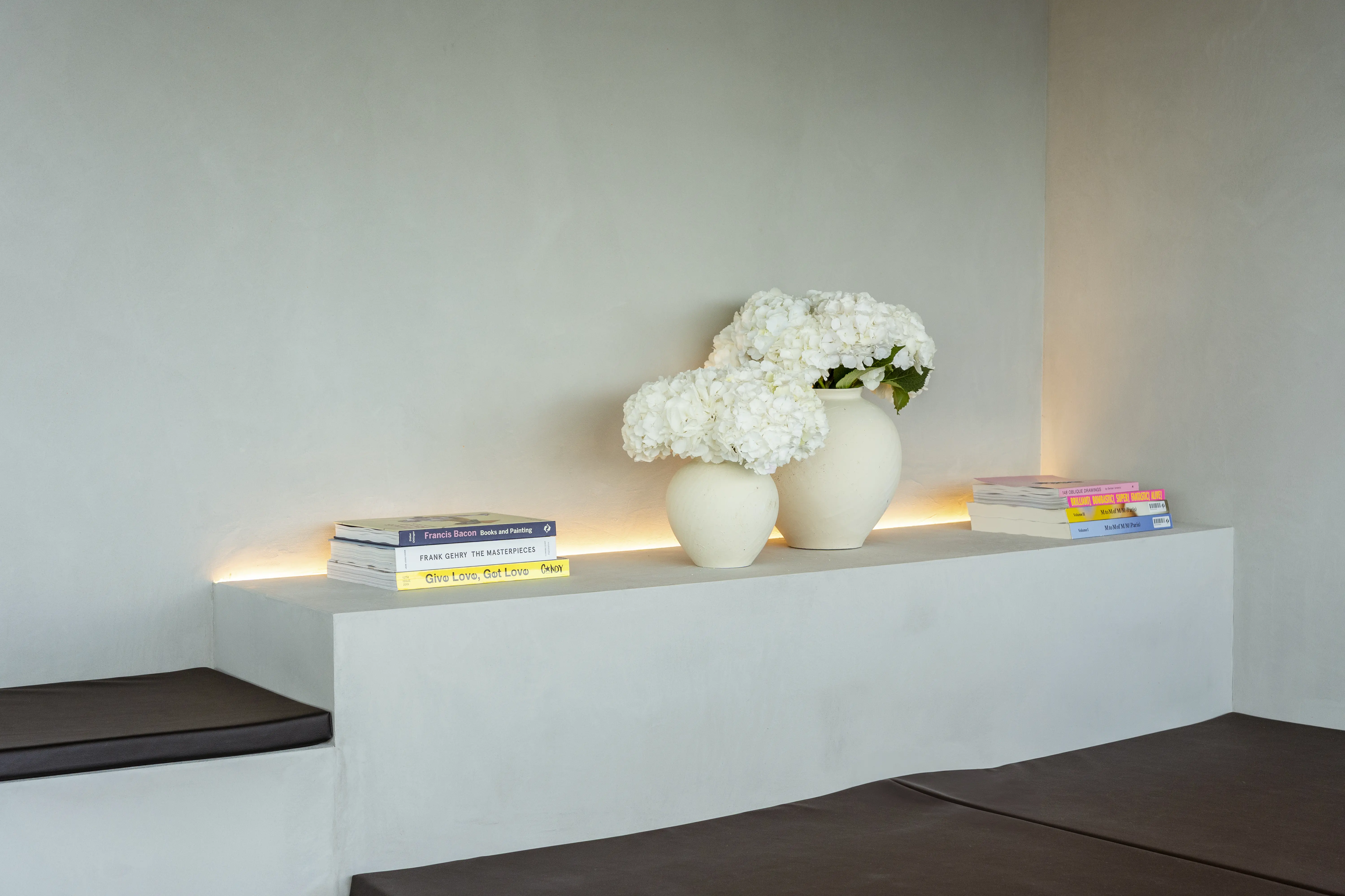 Imagen de detalle de la cafeteria de la cupula con libros y jarrones con flores blancas