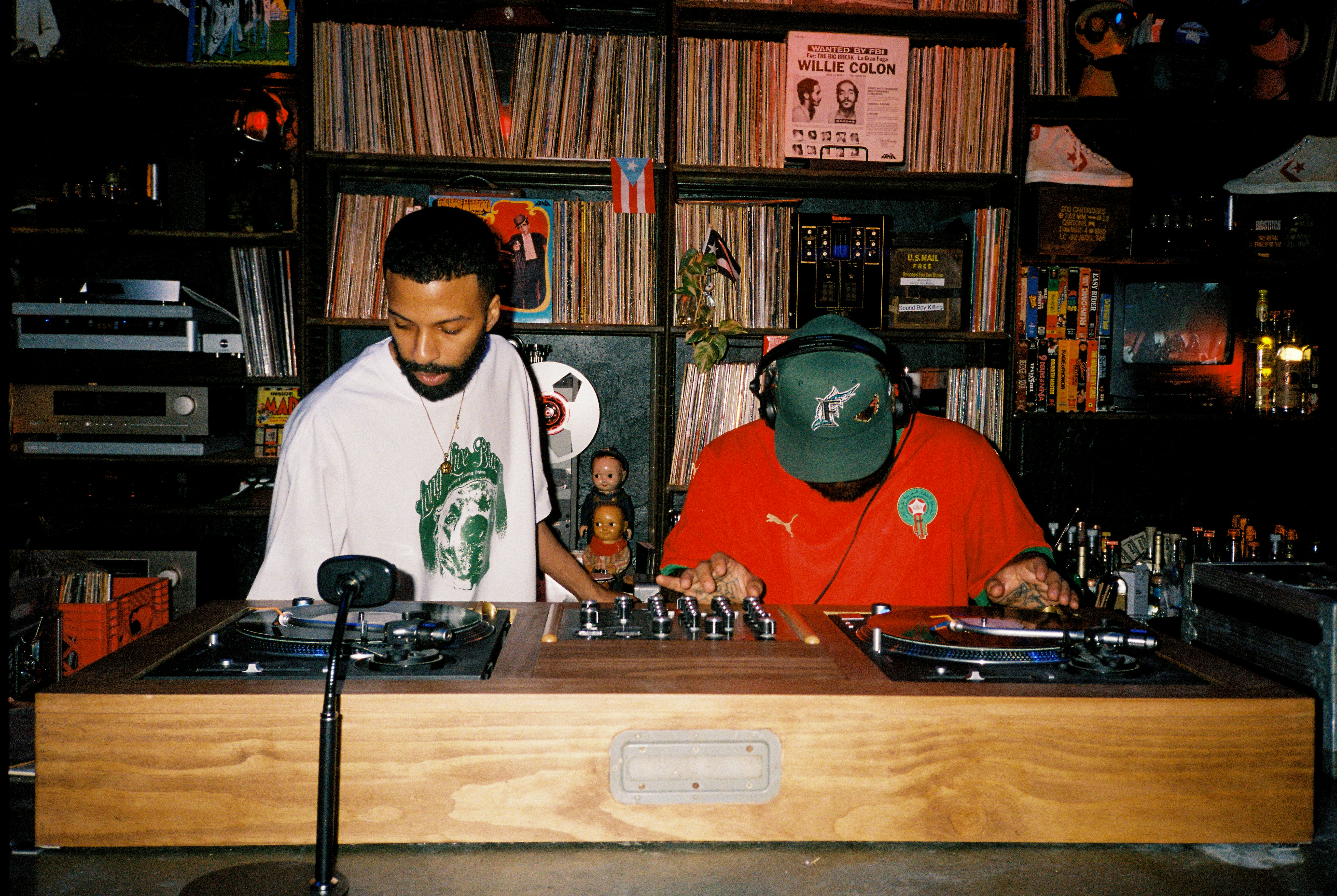 Two djs playing records at a wooden console