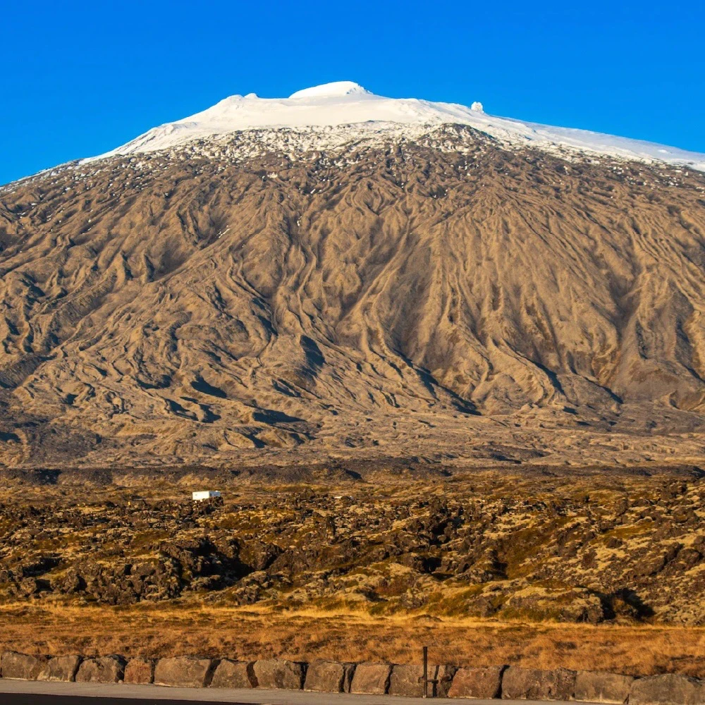 A mountain in Iceland with a bit of snow on the top named Snaefellsjokull Glaciera