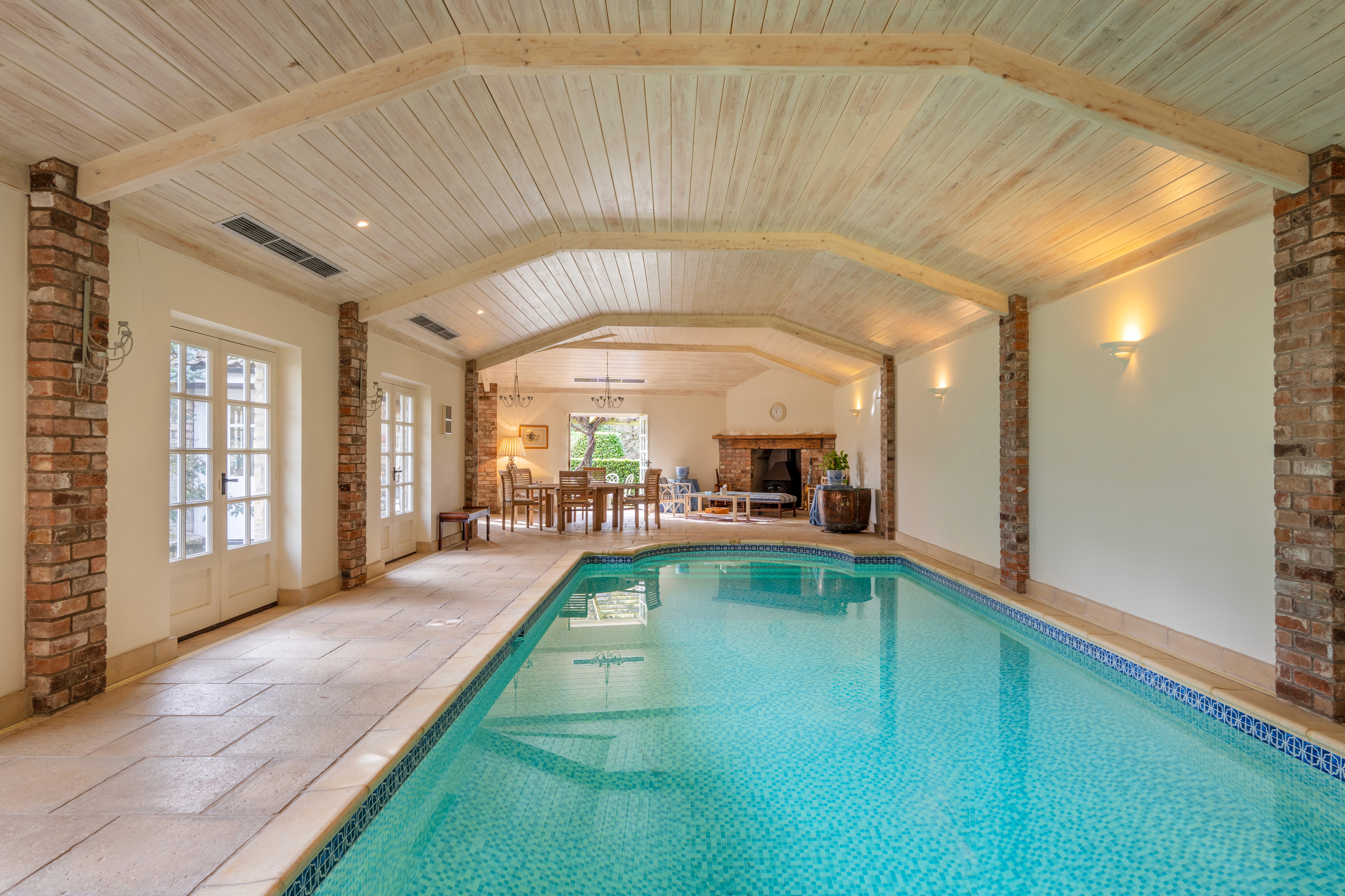 Indoor swimming pool with timber ceiling and garden outlook