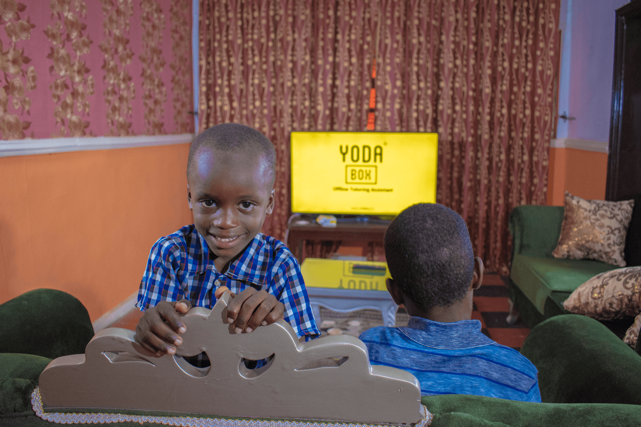 Image of a Kid smiling, Yodabox behind.