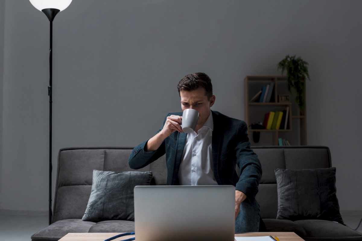 Consultant working late at night on a laptop with a cup of coffee, focused on building his consulting website