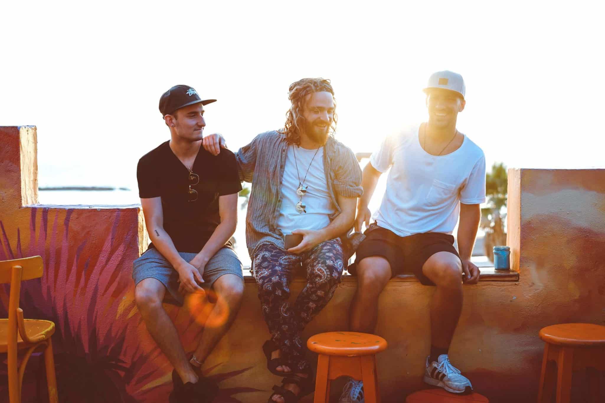 Three friends enjoying a sunny day sitting on a colorful patio.