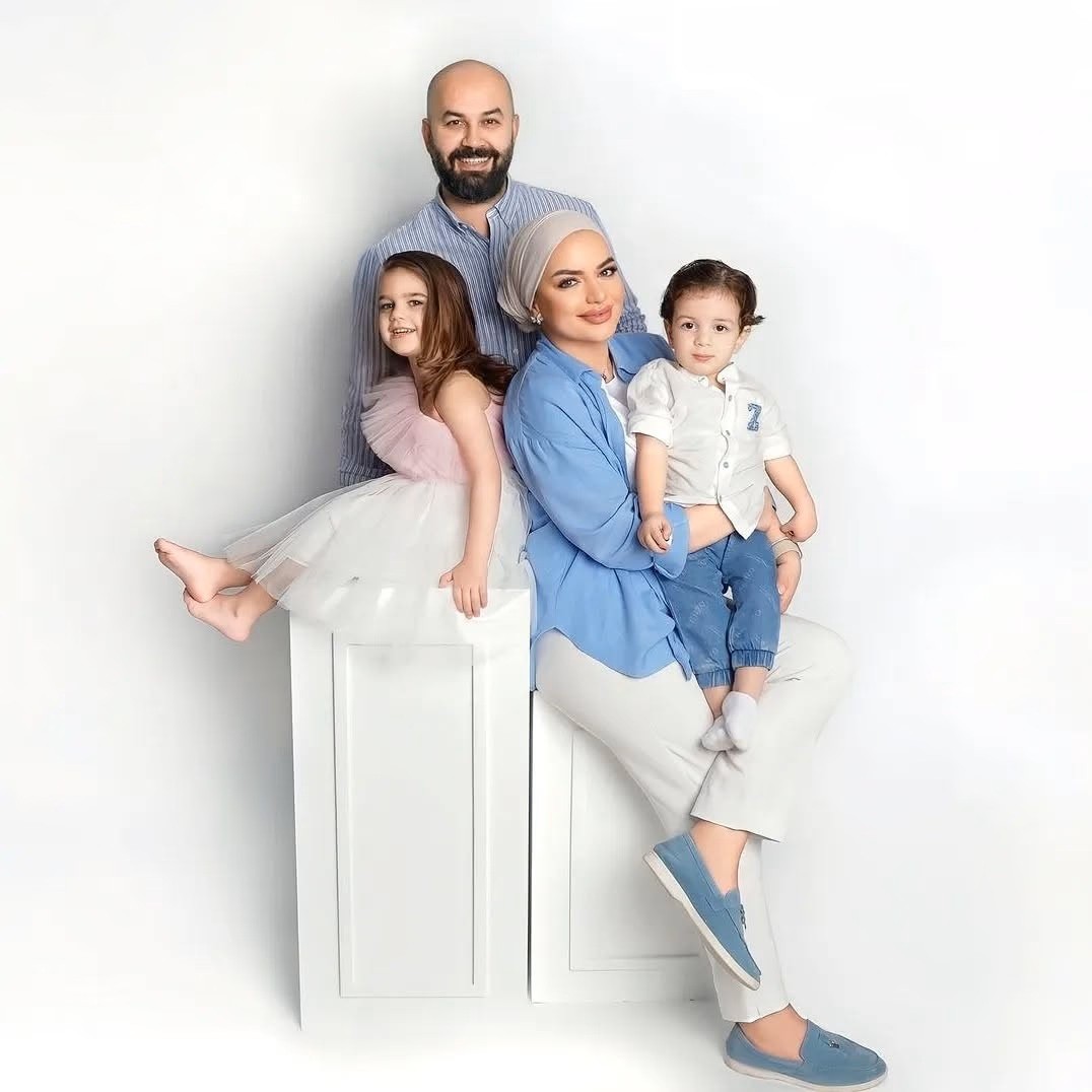 Family of four with a father, mother, young daughter, and a swaddled newborn baby.