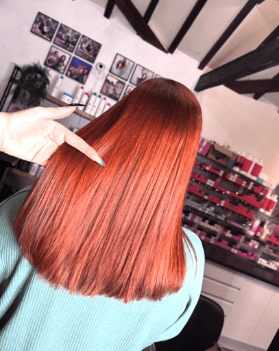 Woman with long hair died red by hairdresser at Inspire Studio Hair Salon