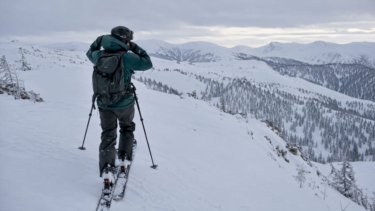 Skier wearing a shell on a snowy mountain ridge