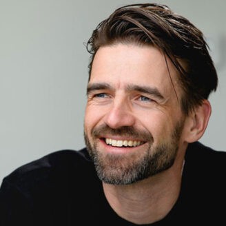 A person smiling and looking serious.