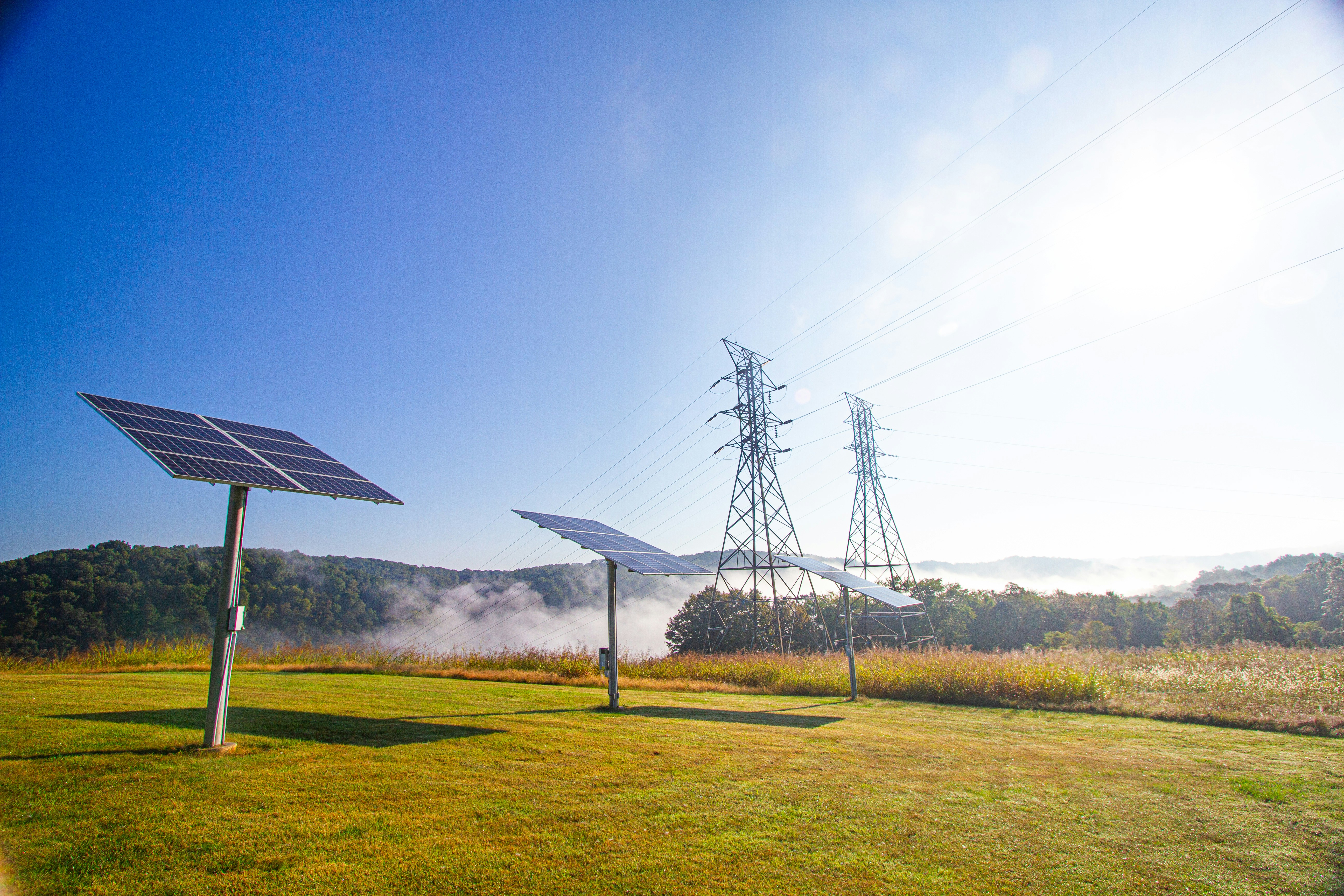 Solar panels and power lines in a grassy field