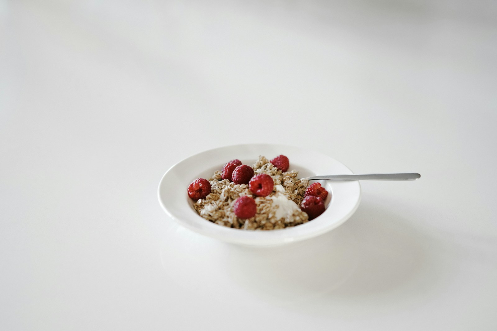 A simple bowl of oats topped with berries and a spoon, illustrating nourishment as the foundation of recovery guided by a dietitian