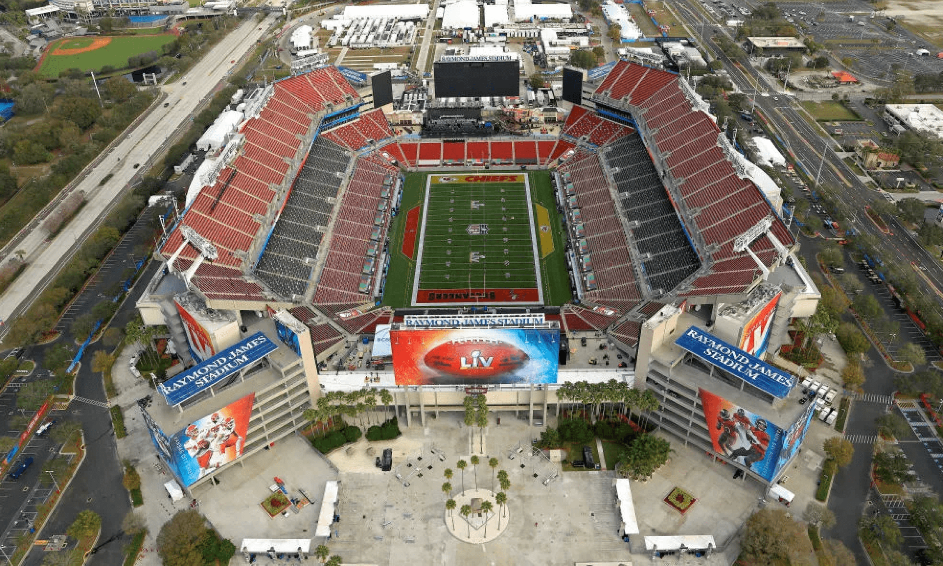Aerial view of Raymond James Stadium, home of the Tampa Bay Buccaneers, showing the distinctive red seating and LIV branding