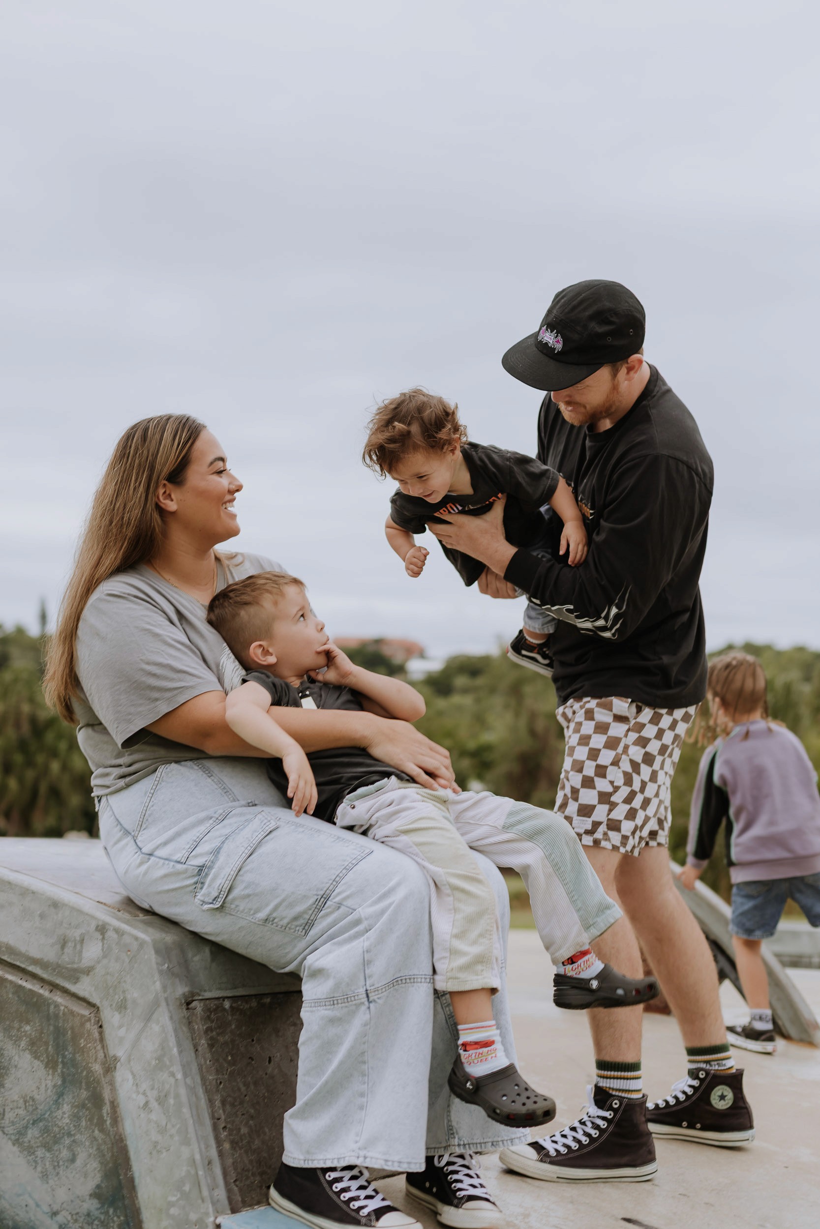Family enjoying time together at a skate park in Mackay with skateboards