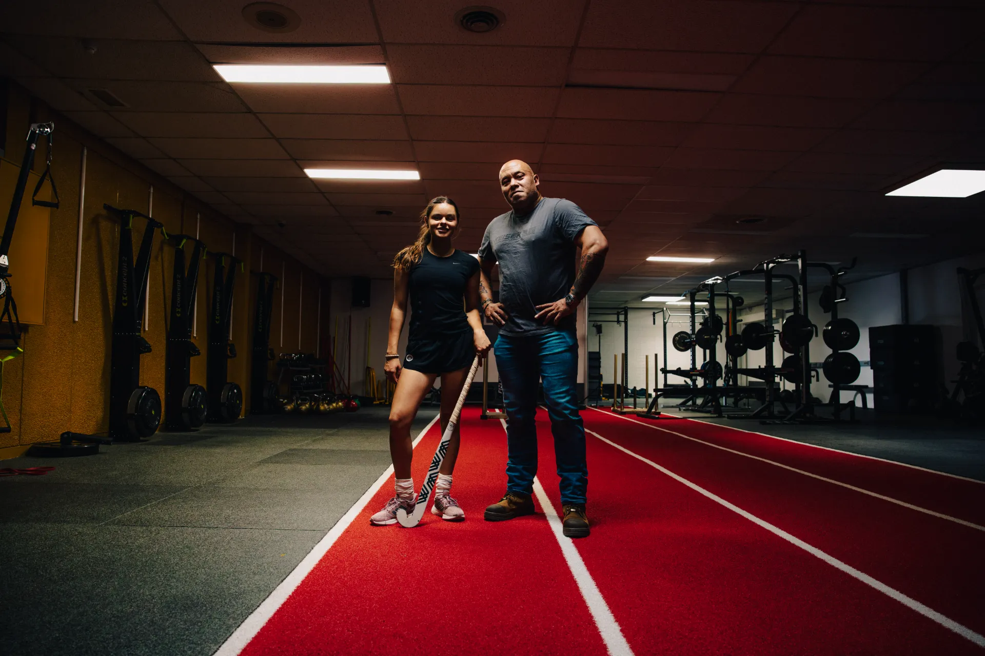 Coach en sporter op de rode sprintbaan van Strive