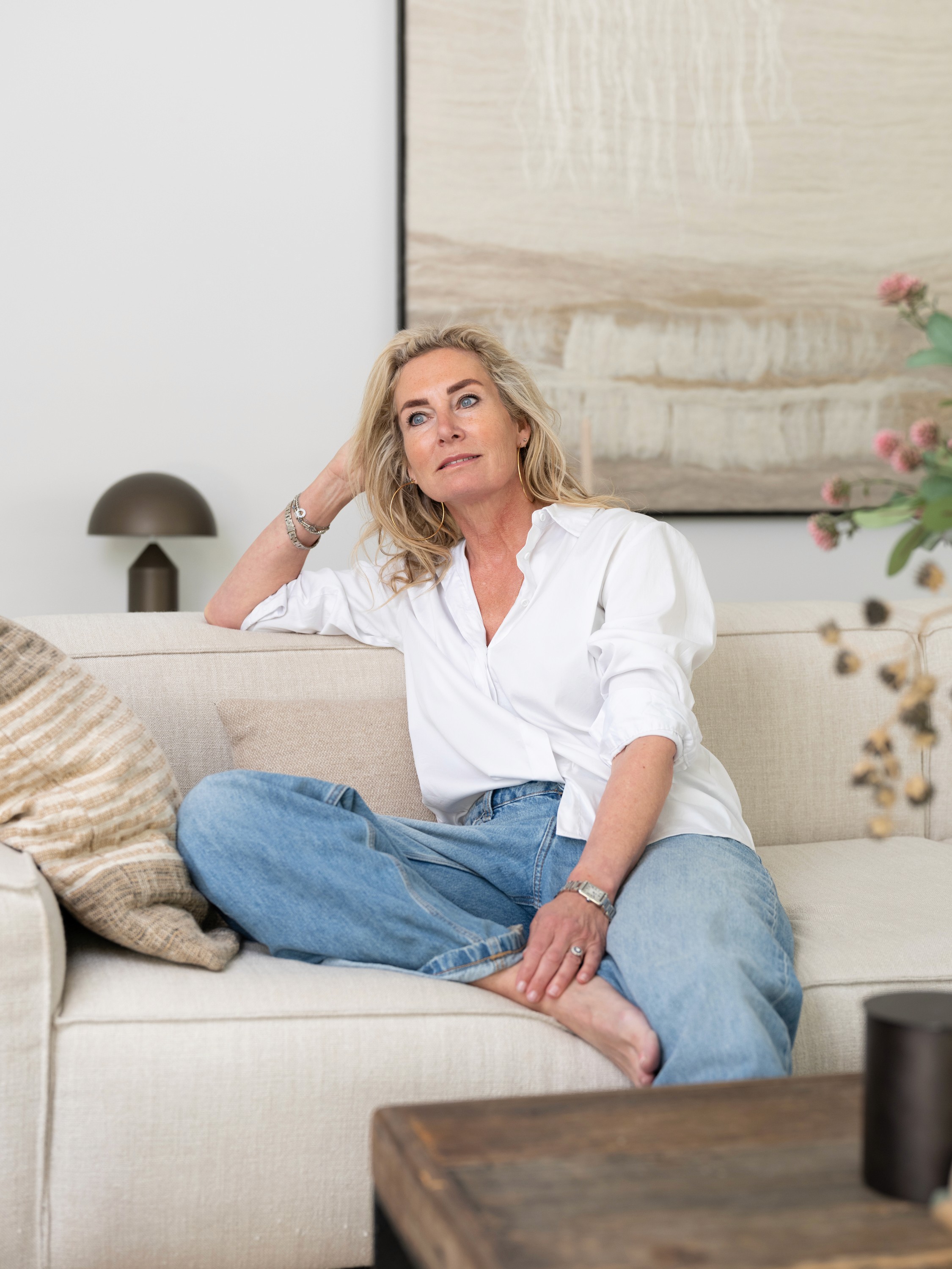 Portrait of Inez Kuiper, sitting on the couch in her living room