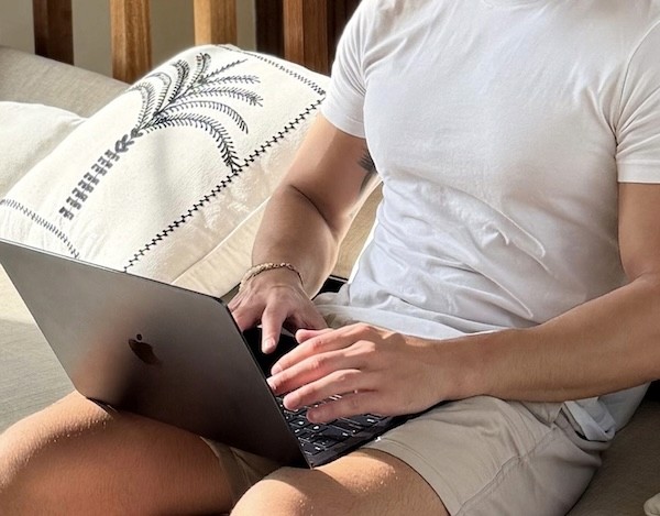 A man working on a laptop, sitting on a couch.