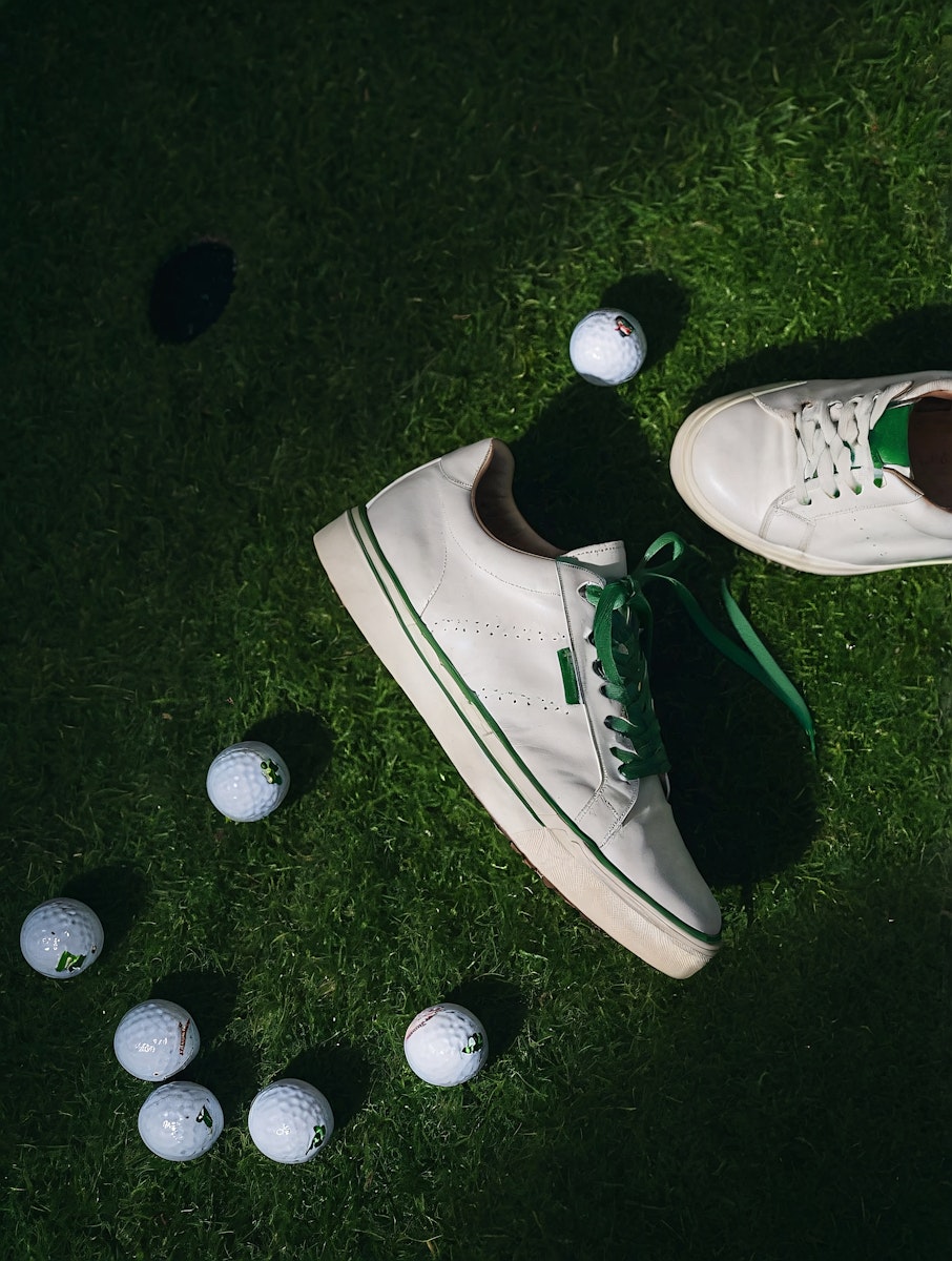 golf balls on the green grass with shoes