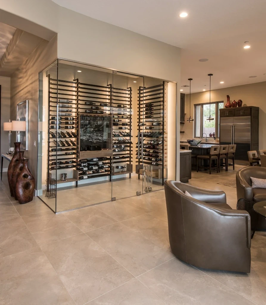Modern glass-enclosed wine wall with black anodized metal racking and walnut shelving in a luxury dining room — custom wine cellar design by Innovative Wine Cellar Designs.