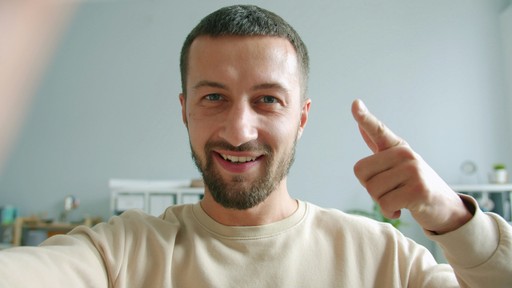 Man smiling and giving a thumbs up gesture.