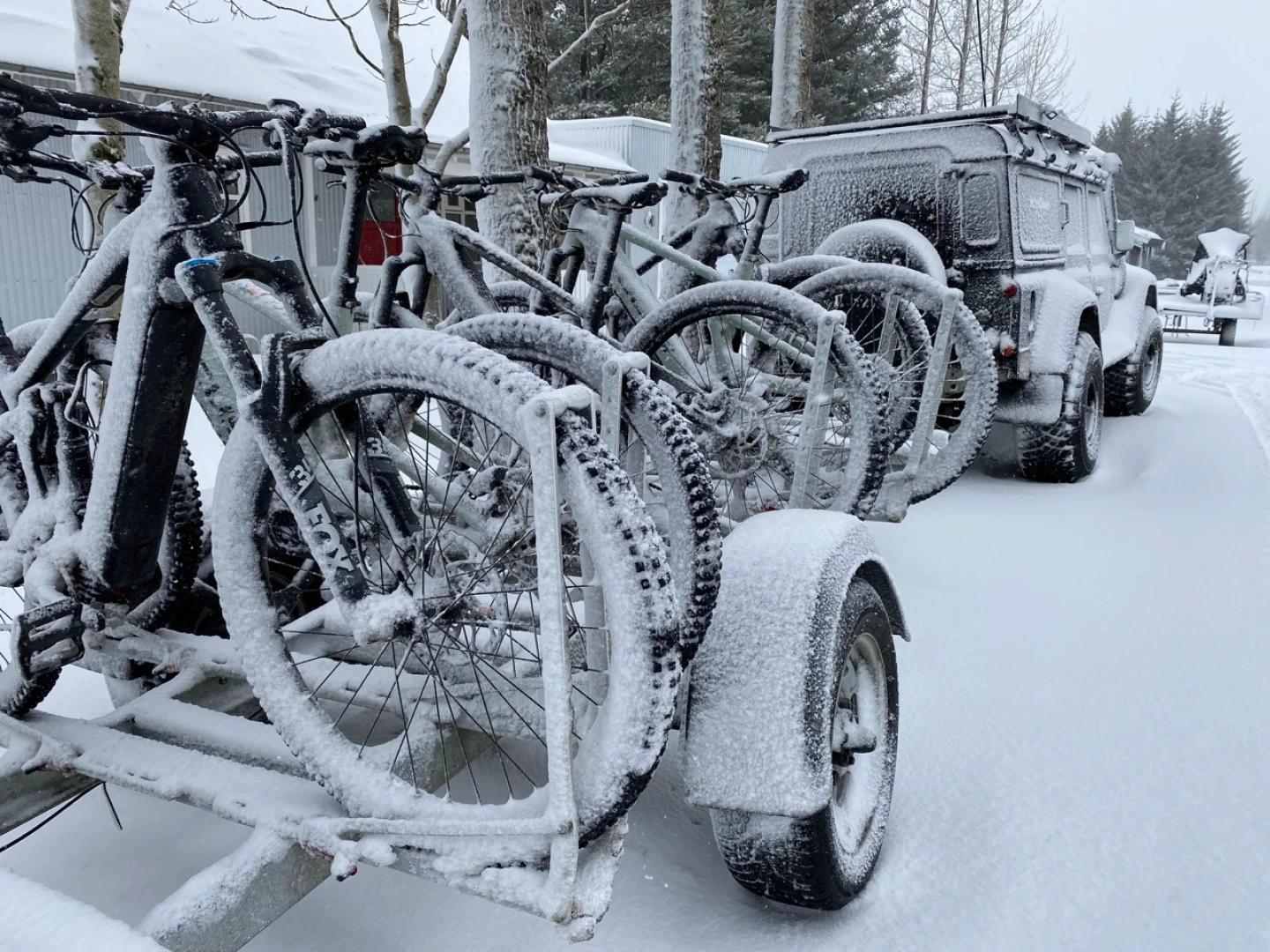 Biketrailer covered with snow with bikes loaded