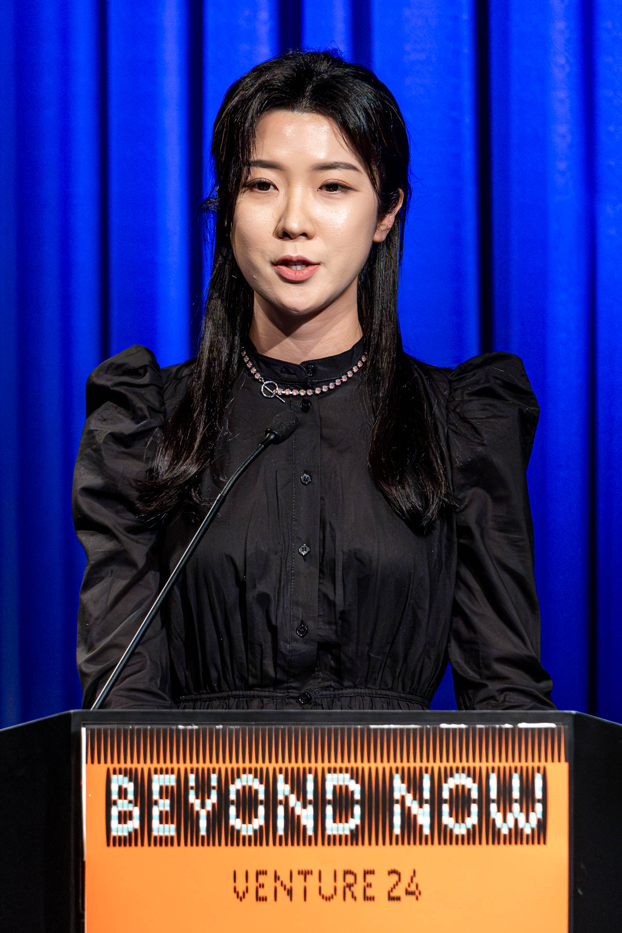 a student at a podium presenting a project in a Theatre
