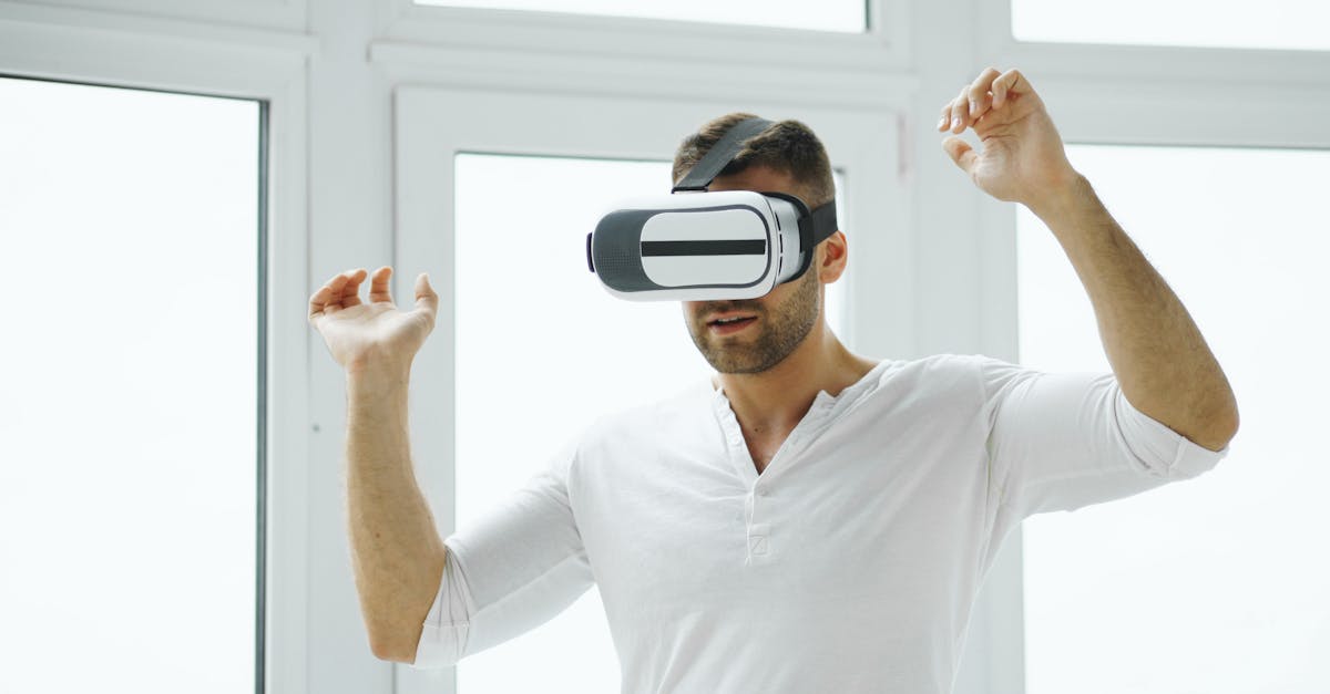 Young man immersed in virtual reality experience using VR headset in a bright room.