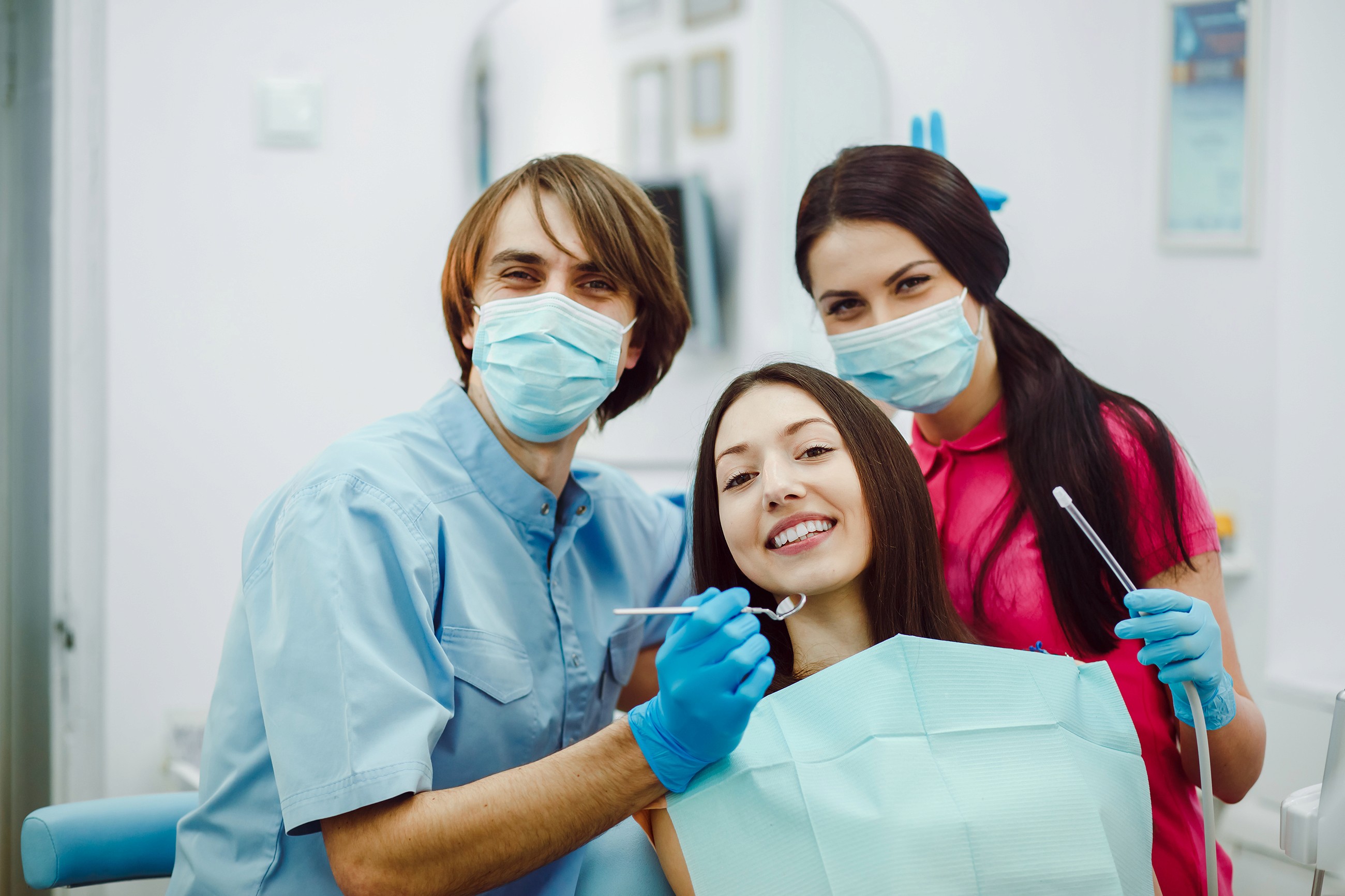 Dental team smiling with a patient in a clinic setting