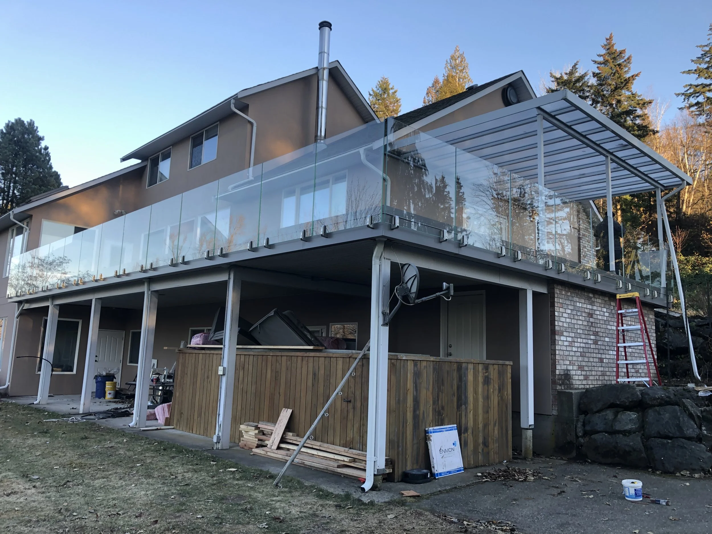 A second story deck with frameless glass railings by Tenmar in the Fraser Valley.