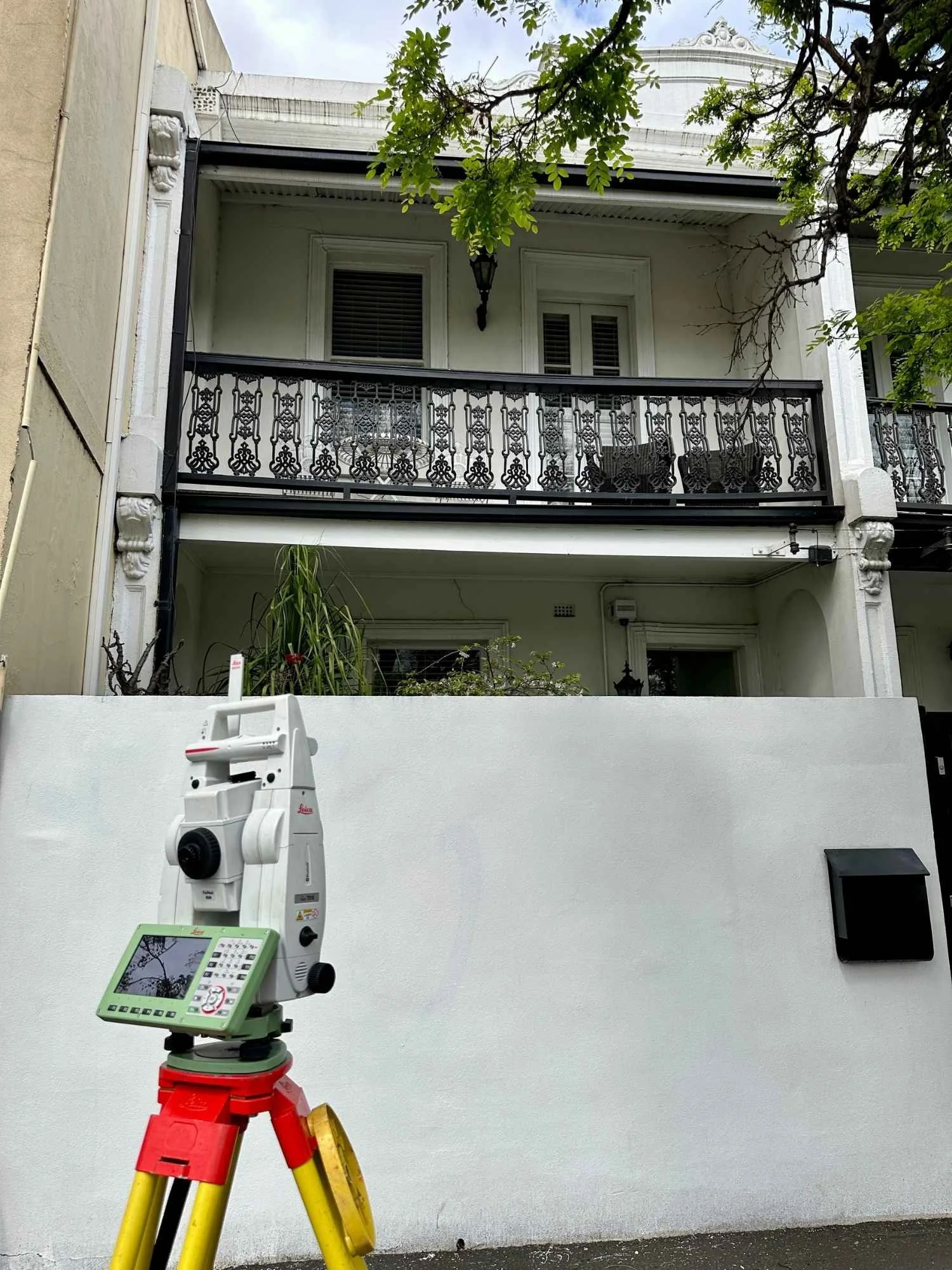 Land Surveying Equipment set up on a tripod at the front of a terrace house in Melbourne