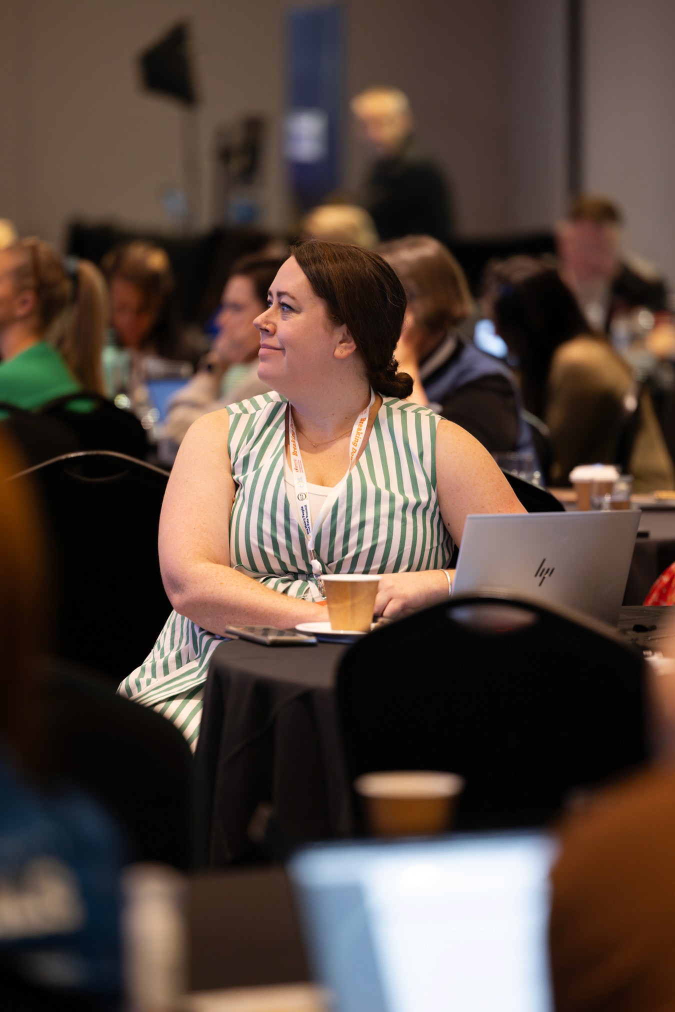 Woman looking away from computer at conference