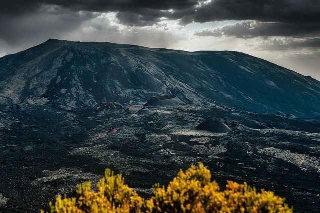 Réunion Island’s active volcano dominates a dramatic, untamed landscape, where nature sets its own rhythm and the raw beauty of the Indian Ocean’s wild heart unfolds under stormy skies.