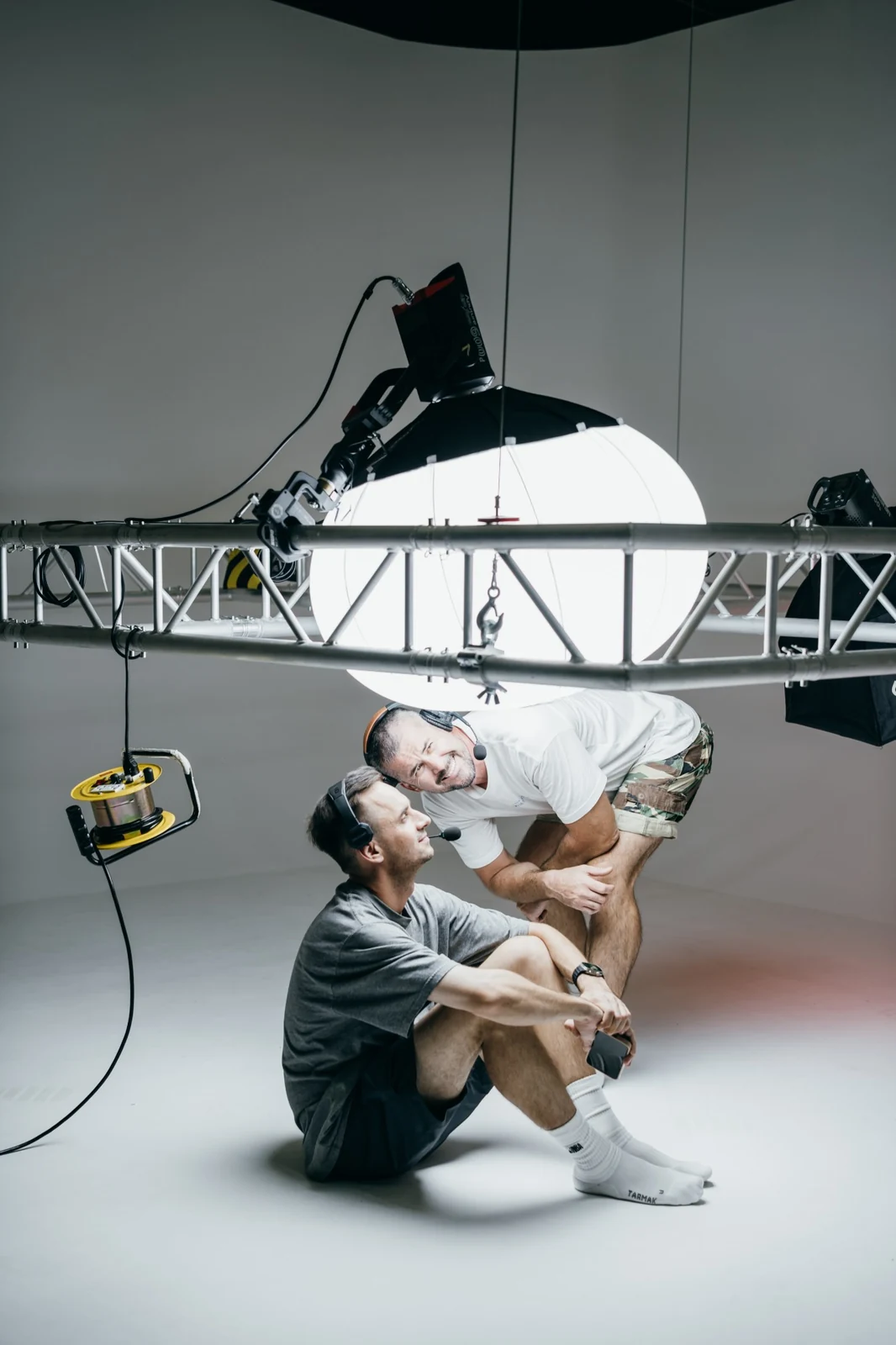 Two crew members under the overhead truss and lantern softbox during the Chery V23 shoot