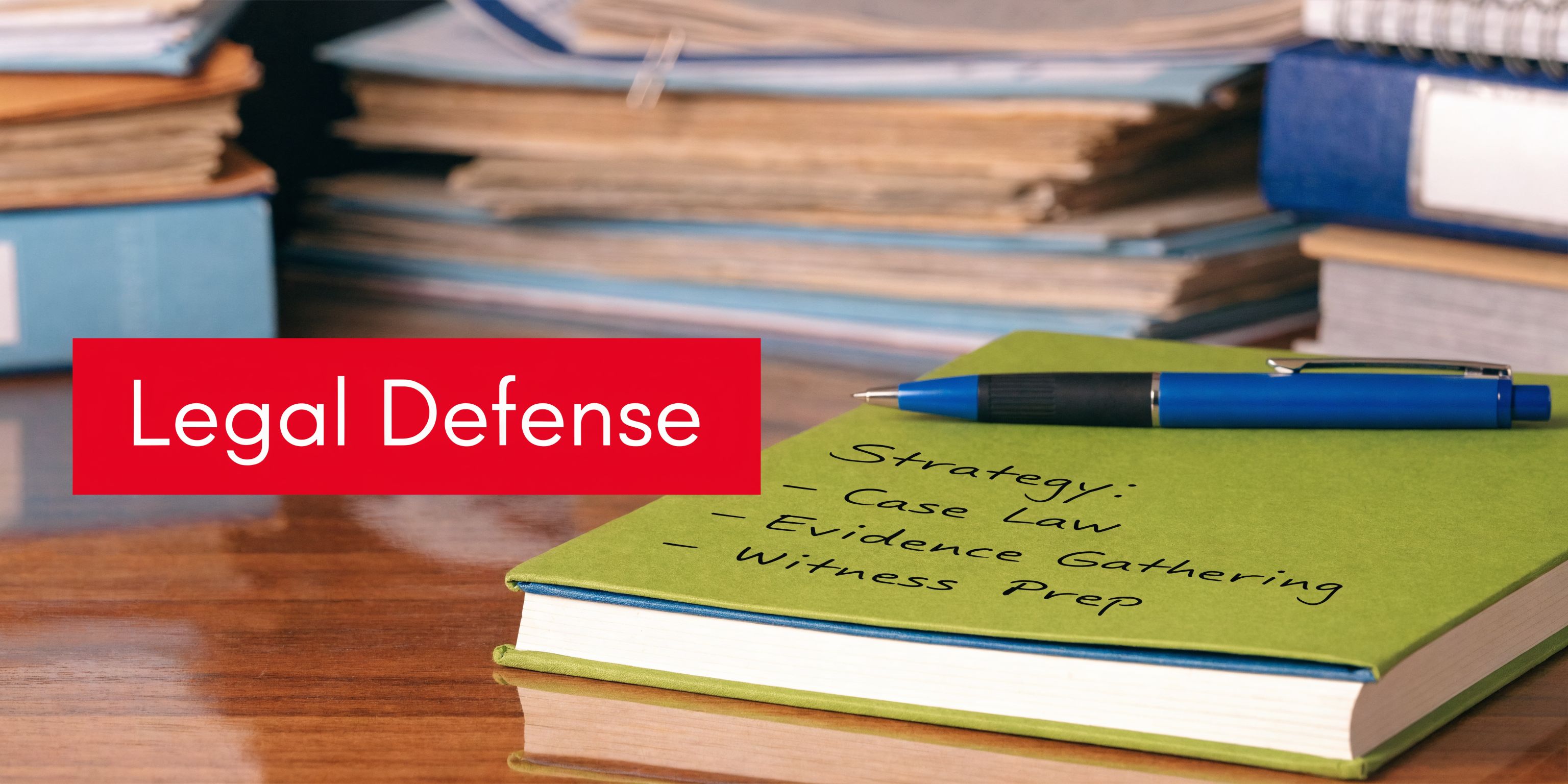 A legal notebook with handwritten strategy notes, a pen, and stacks of law files in the background.