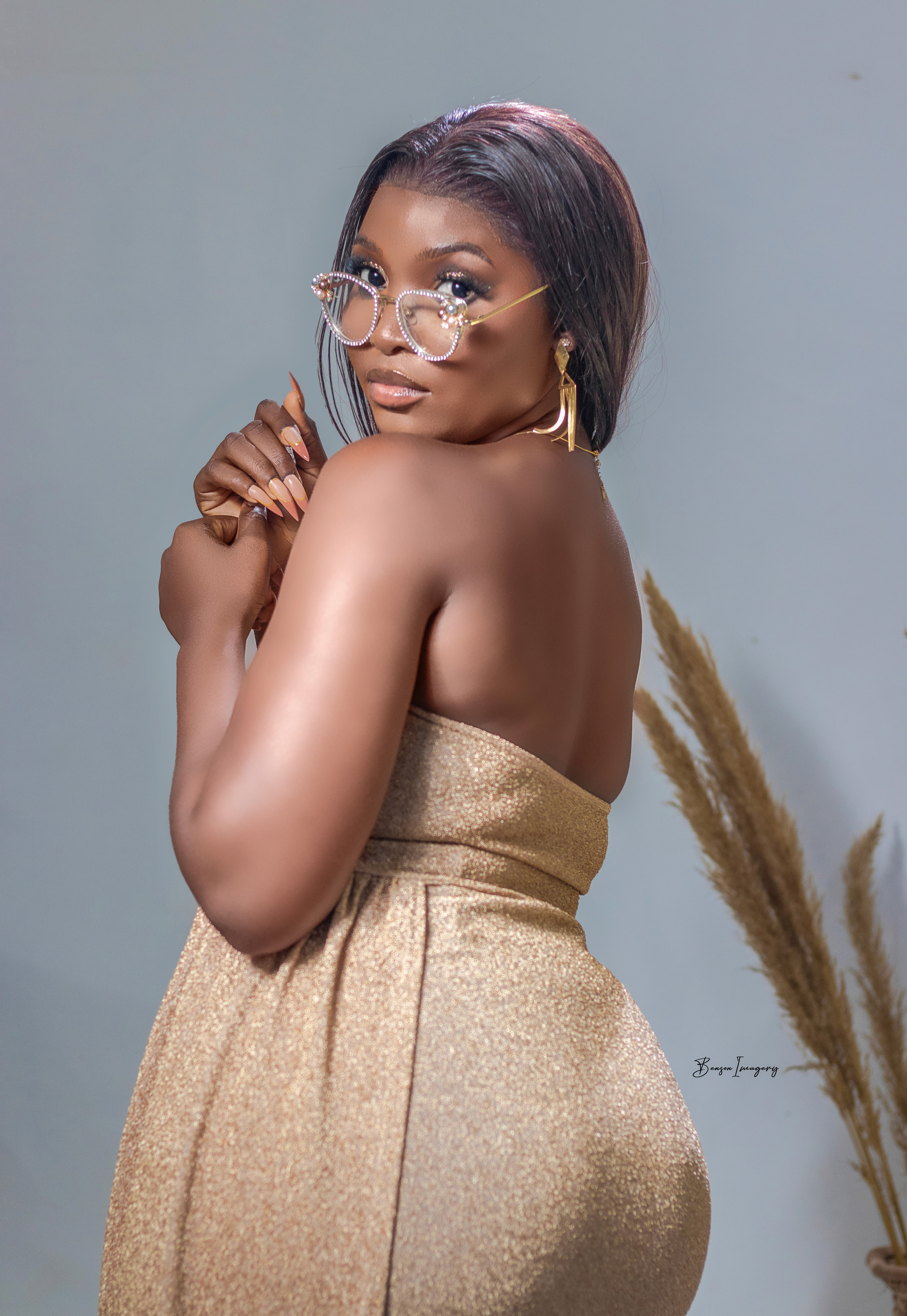 A woman sits cross-legged with eyes closed, wearing a white blouse and a long purple skirt, looking serene.