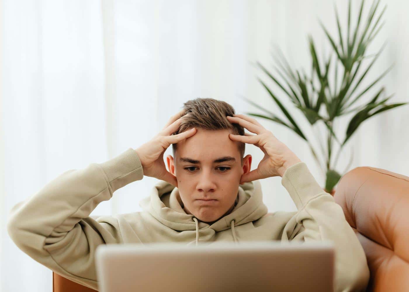Man looking frustrated while working on a laptop