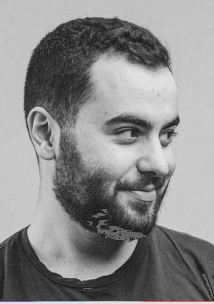 Young woman in a white shirt with a colorful gradient print, against a plain background.