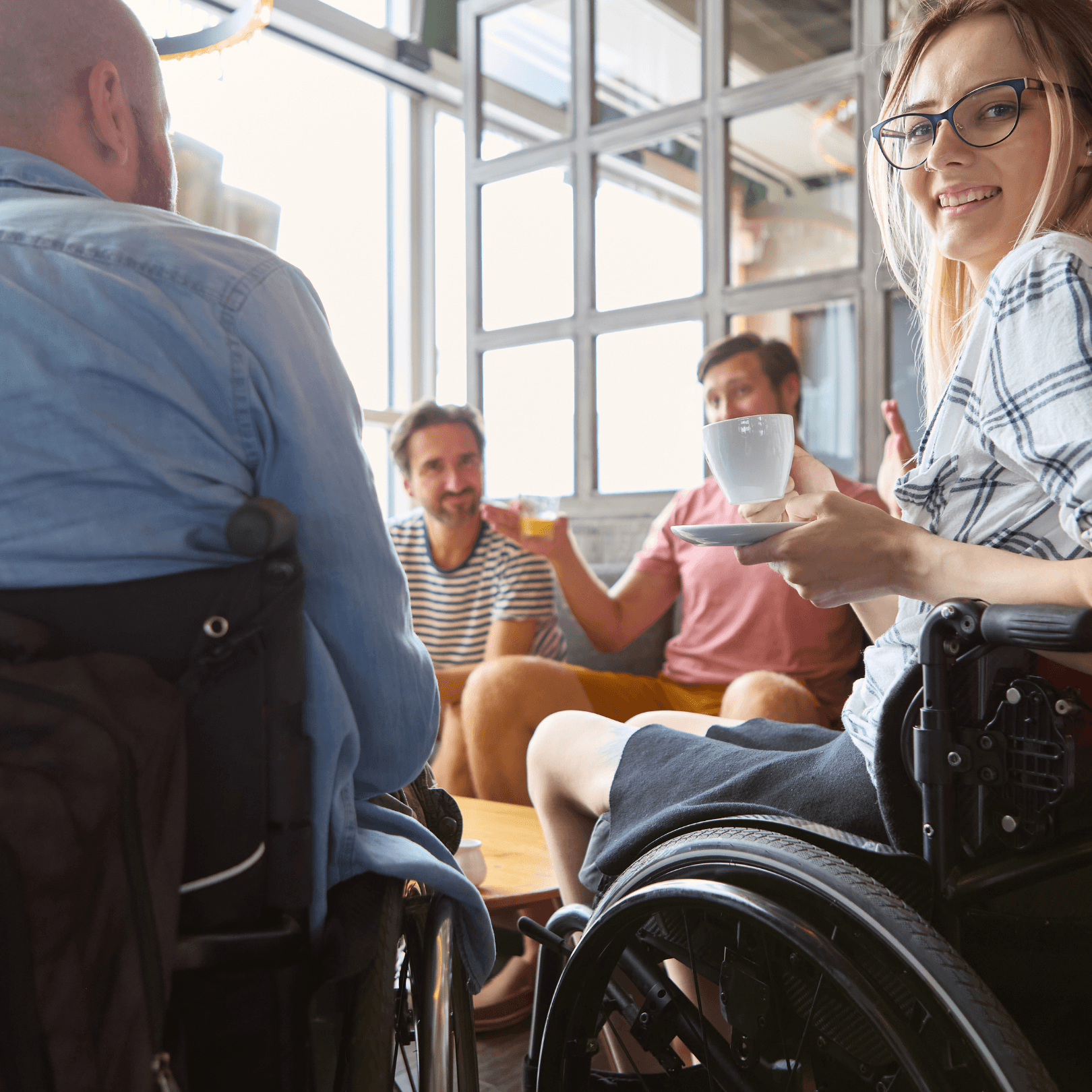 A woman in a wheelchair having a coffee