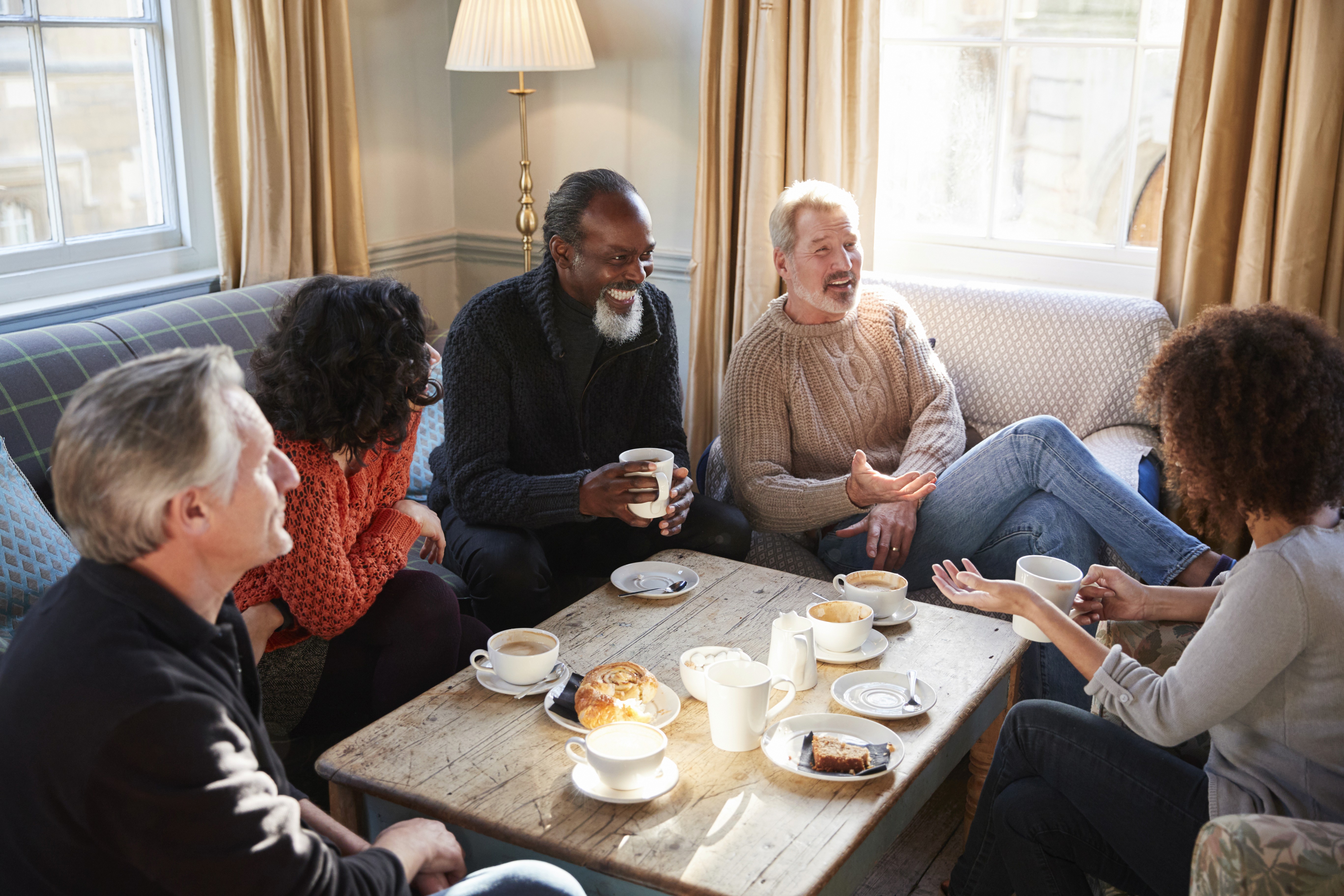 Group discussing retirement plans in a relaxed setting over coffee.