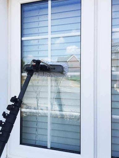 A person cleaning wall and window in the air