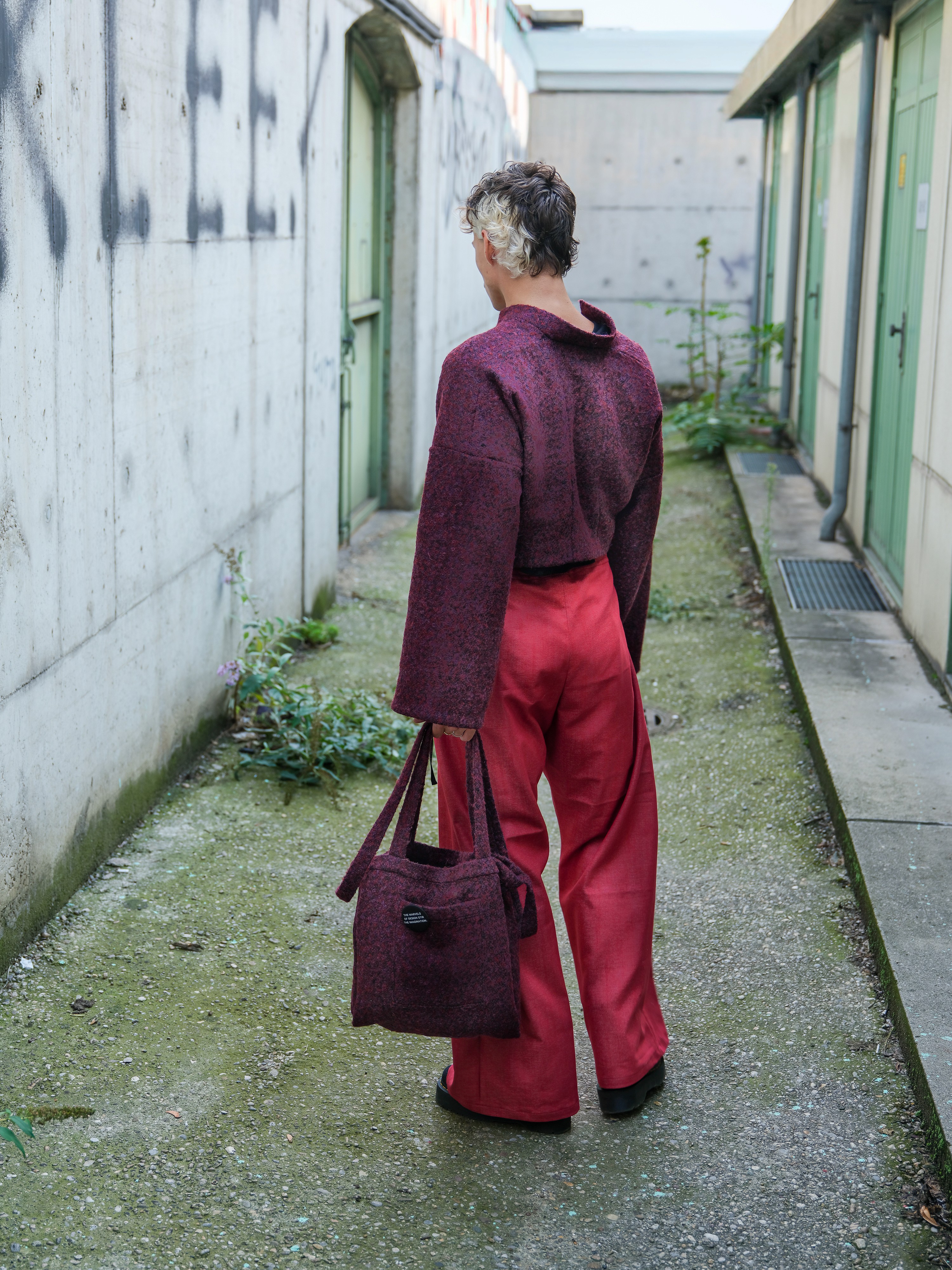 model from back with purple jacket and matching bag