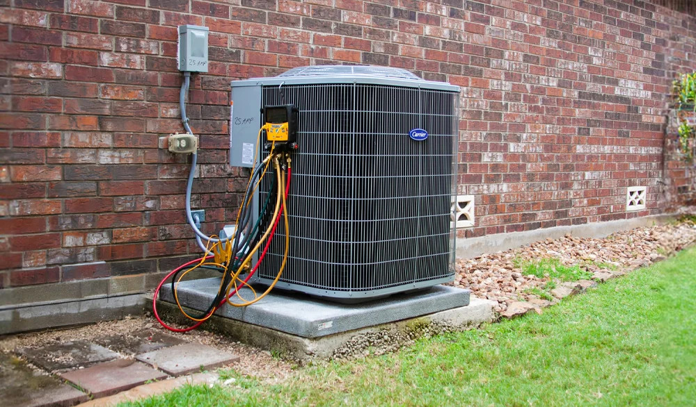 A hand adjusts a modern smart thermostat mounted on a wall. The black circular display shows the temperature set to 78 degrees Fahrenheit with a green leaf icon below the number.