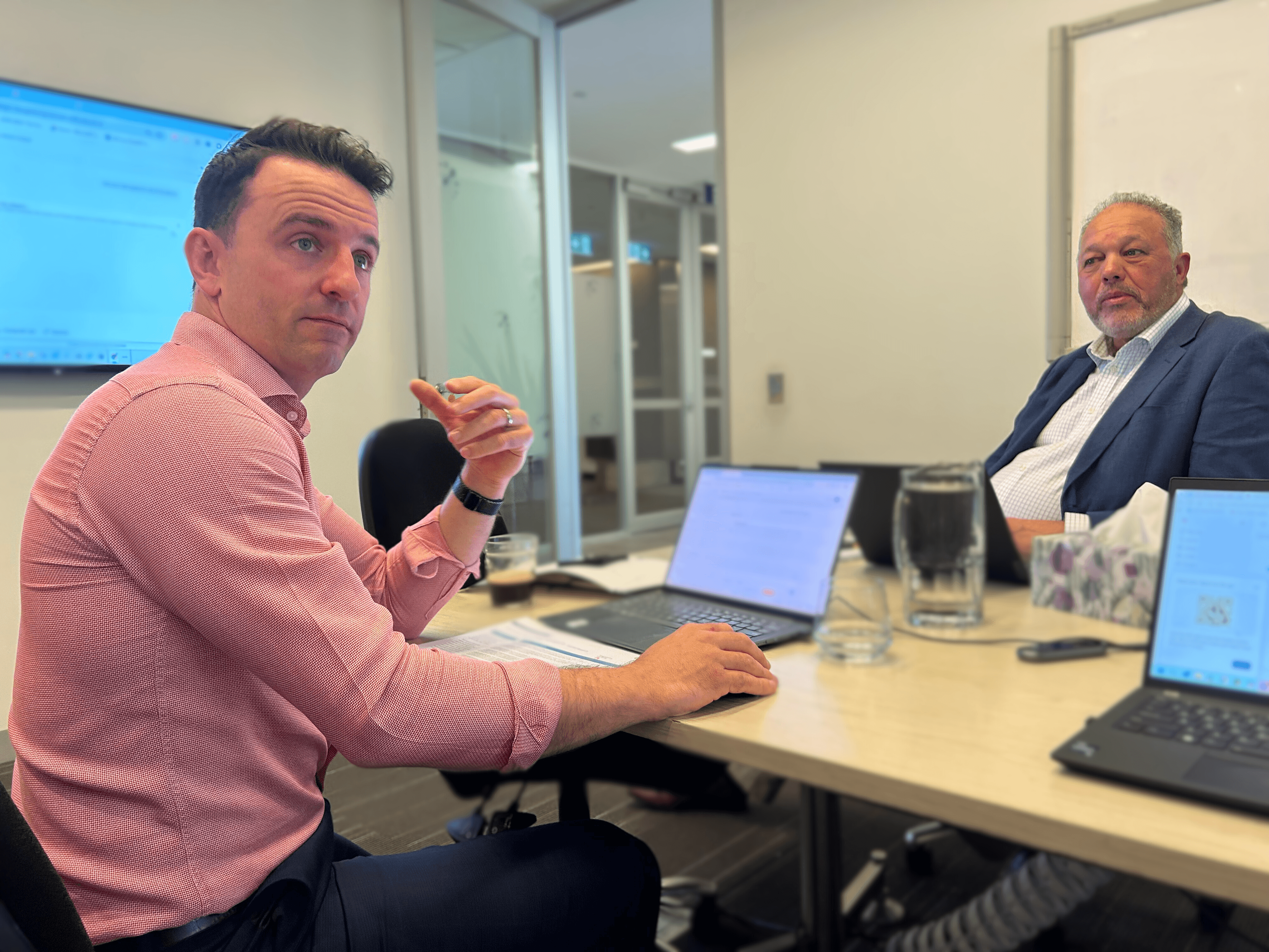 man wearing gray polo shirt beside dry-erase board