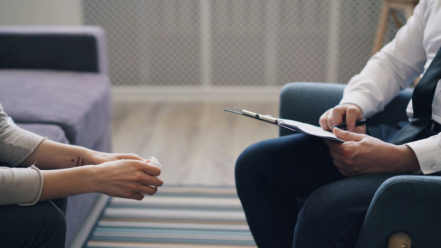 A clinician taking notes during a consultation